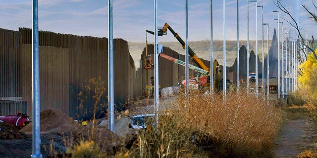 FILE - Crews construct a section of border wall in San Bernardino National Wildlife Refuge, Tuesday, Dec. 8, 2020, in Douglas, Ariz. President Biden on Wednesday ordered a "pause" on all wall construction within a week. (AP Photo/Matt York)