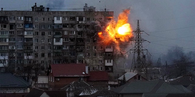 An explosion is seen in an apartment building after Russian tank fire in Mariupol, Ukraine, Friday, March 11, 2022.