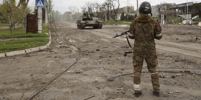 A serviceman of Donetsk People's Republic militia stands at a check point in Mariupol, in territory under the government of the Donetsk People's Republic, eastern Ukraine, Wednesday, May 4, 2022. 