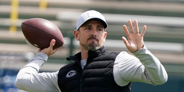 FILE - Green Bay Packers' head coach Matt LaFleur throws a pass at the NFL football team's practice field training camp Tuesday, May 24, 2022, in Green Bay, Wis.