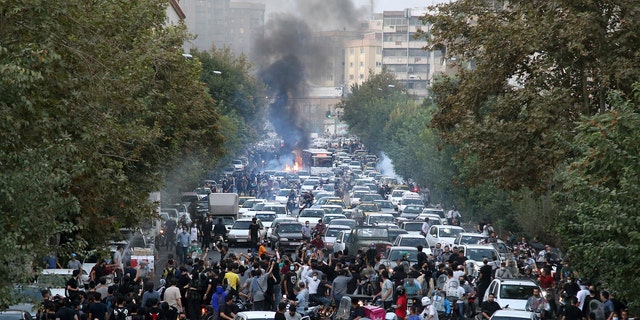 Protesters chant slogans during a protest over the death of a woman who was detained by the morality police, in downtown Tehran, Iran. 