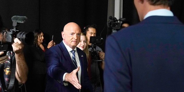 Arizona Democratic Sen. Mark Kelly, left, reaches out to shake hands with his Republican challenger Blake Masters before a televised debate in Phoenix Oct. 6, 2022. 