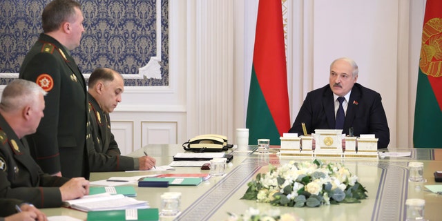 Belarusian President Alexander Lukashenko, right, attends a meeting with military top officials in Minsk, Belarus, Monday, Oct. 10, 2022.