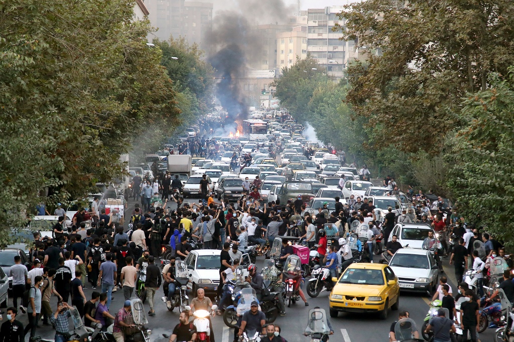 protesters chant slogans during a protest over the death of a woman who was detained by the morality police, in downtown Tehran, Iran, Sept. 21, 2022.