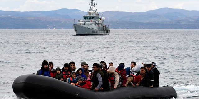 Migrants arrive with a dinghy accompanied by a Frontex vessel at the village of Skala Sikaminias, on the Greek island of Lesbos, after crossing the Aegean Sea from Turkey, on Feb. 28, 2020. 