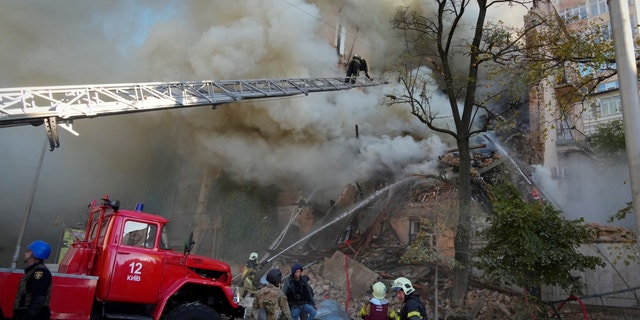 Firefighters on the scene after a drone severely damaged buildings in Kyiv, Ukraine, Monday, Oct. 17, 2022.