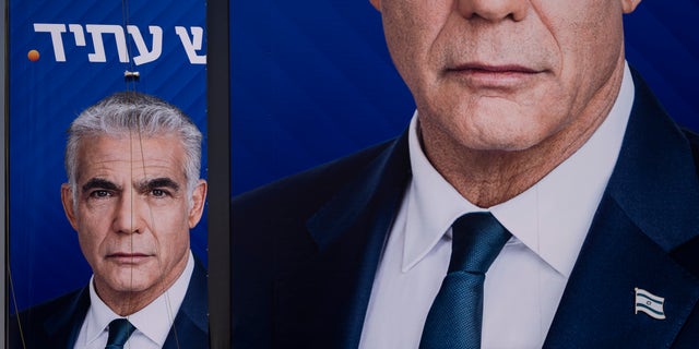 Workers hang an election campaign billboard for the Yesh Atid party, showing Israeli Prime Minister and the head of the party Yair Lapid, in Ramat Hasharon, Israel, Oct. 23, 2022. Israel is heading into its fifth election in under four years Nov. 1.  