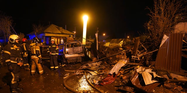 Firefighters work at the scene after a warplane crashed into a residential area in Irkutsk, Russia, Sunday, Oct. 23, 2022. 