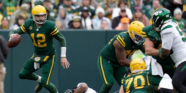 Green Bay Packers quarterback Aaron Rodgers (12) scrambles away from New York Jets defensive tackle Sheldon Rankins (98) during the first half of a game Sunday, Oct. 16, 2022, in Green Bay, Wis.