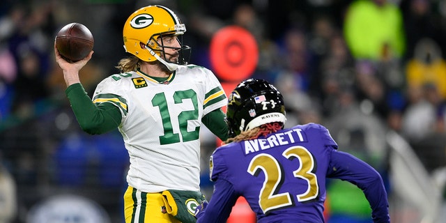 Green Bay Packers quarterback Aaron Rodgers (12) throws as he is pressured by Baltimore Ravens cornerback Anthony Averett in the first half of a game Dec. 19, 2021, in Baltimore.