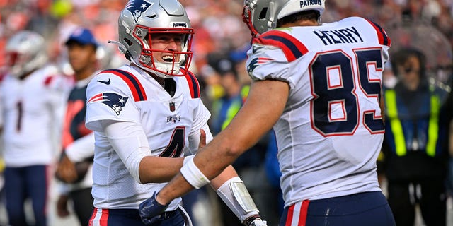 New England Patriots quarterback Bailey Zappe (4) celebrates after throwing a touchdown pass to tight end Hunter Henry (85) during the second half against the Cleveland Browns on Oct. 16, 2022, in Cleveland.