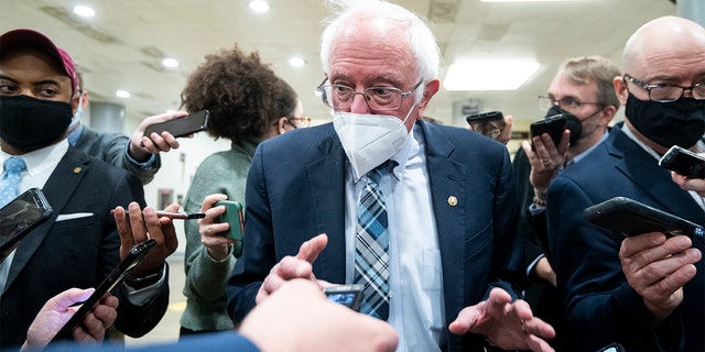 Sen. Bernie Sanders, I-Vt., speaks with reporters in the Senate subway on Monday, Dec. 13, 2021.