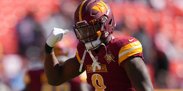 Washington Commanders running back Brian Robinson Jr. gestures as he warms up for the Tennessee Titans game, Sunday, Oct. 9, 2022, in Landover, Maryland.