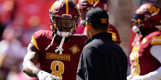 Washington Commanders running back Brian Robinson Jr. speaks with head coach Ron Rivera before the Tennessee Titans game, Sunday, Oct. 9, 2022, in Landover, Maryland.