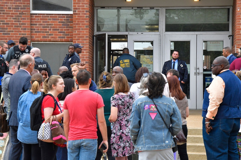 Students and parents wait outside the south entrance to the Central Visual and Performing Arts High School after the shooting on October 24, 2022.