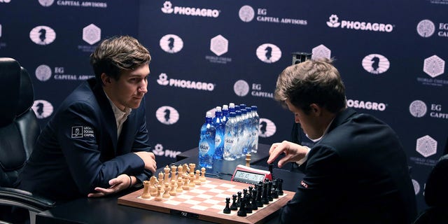 Sergey Karjakin of Russia, left, and current World Chess Champion Magnus Carlsen of Norway prepare for the start of the first game of their rapid chess match playoff at the 2016 World Chess Championship match in New York Nov. 30, 2016.