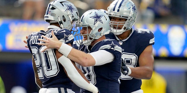 Dallas Cowboys running back Tony Pollard (20),quarterback Cooper Rush (10) and offensive tackle Terence Steele (78) celebrate a touchdown scored on a run by Pollard in the first half of an NFL football game against the Los Angeles Rams, Sunday, Oct. 9, 2022, in Inglewood, Calif.