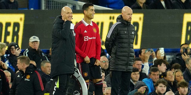 Manchester United's Cristiano Ronaldo stands next to Manchester United head coach Erik ten Hag, right, while waiting to replace teammate Anthony Martial during a Premier League soccer match against Everton at Goodison Park, in Liverpool, England, Sunday, Oct. 9, 2022.