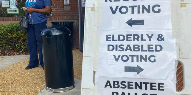 Signs showing the way for voters stands outside a Cobb County voting building during the first day of early voting, Monday, Oct. 17, 2022, in Marietta, Ga.