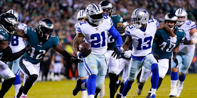 Dallas Cowboys' Ezekiel Elliott, center, runs for a touchdown during the second half of an NFL football game against the Philadelphia Eagles on Sunday, Oct. 16, 2022, in Philadelphia. 