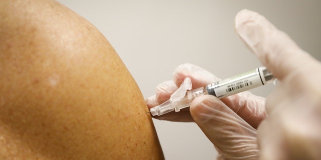 A pharmacist administers a free flu shot vaccine to a customer at a CVS Health Corp. Pharmacy in Miami, Florida, U.S., on Wednesday, Sept. 30, 2020. 