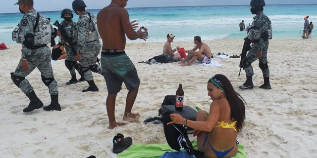 Members of the Tourist Security Battalion of the National Guard patrol a beach in Cancun, Mexico, on Dec. 2, 2021.