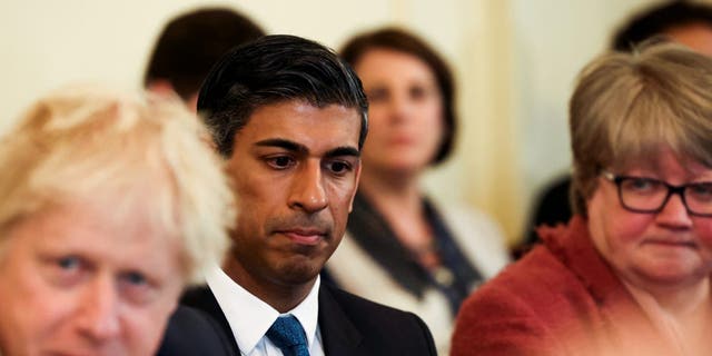 British Chancellor of the Exchequer Rishi Sunak, center, listens as Prime Minister Boris Johnson, left, speaks at the weekly cabinet meeting at Downing Street on May 17, 2022 in London. 