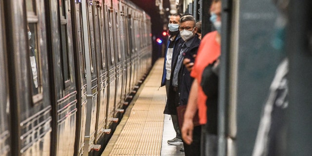 Commuters wait on the platform at the Times Square subway station in New York City, on Wednesday, May 25, 2022. 