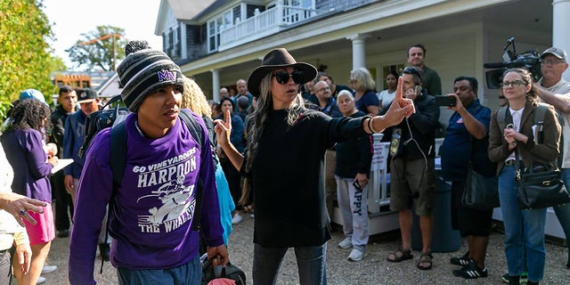 A Venezuelan migrant is led onto a bus at St. Andrews Episcopal Church Sept. 16, 2022, in Edgartown, Mass., on the island of Martha's Vineyard.