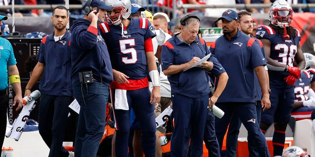 From left, New England Patriots offensive assistant/quarterbacks coach Joe Judge and quarterback Brian Hoyer confer as head coach Bill Belichick makes notes during a game between the New England Patriots and the Baltimore Ravens at Gillette Stadium in Foxborough, Massachusetts, on Sept. 25, 2022.