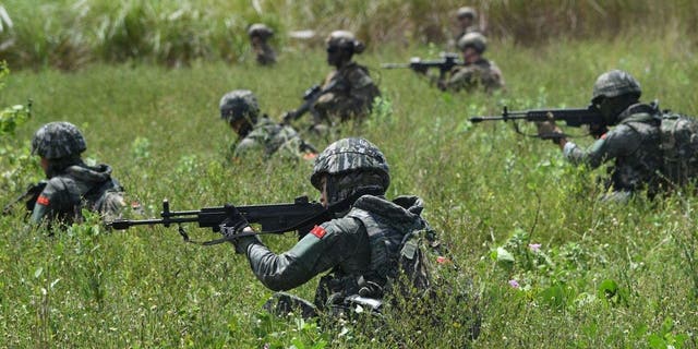 South Korean and U.S. Marines take positions during a joint amphibious landing exercise with their Filipino counterparts on a beach facing the South China Sea in San Antonio town, Zambales province, Oct. 7, 2022. 