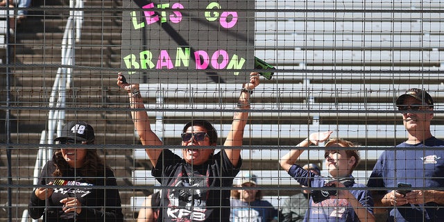 A NASCAR fan holds a "Lets Go Brandon!" sign during the NASCAR Xfinity Series Andy's Frozen Custard 335 at Texas Motor Speedway on October 16, 2021 in Fort Worth, Texas.