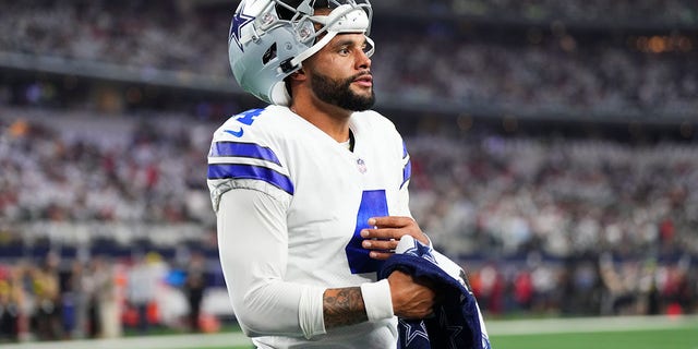 Dak Prescott of the Dallas Cowboys uses a towel to wipe his hand against the Tampa Bay Buccaneers Sept. 11, 2022, in Arlington, Texas 