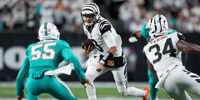 Joe Burrow, #9 of the Cincinnati Bengals, runs with the ball while being chased by Jerome Baker, #55 of the Miami Dolphins, in the second quarter at Paycor Stadium on Sept. 29, 2022 in Cincinnati.