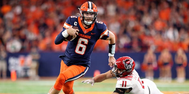 Garrett Shrader, #6 of the Syracuse Orange, runs the ball as Payton Wilson, #11 of the North Carolina State Wolfpack, attempts to tackle Shrader during the third quarter at JMA Wireless Dome on Oct. 15, 2022 in Syracuse, New York. 