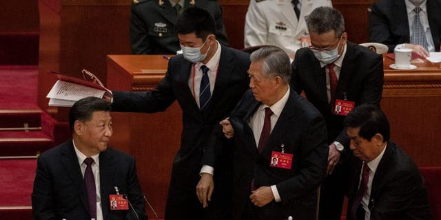 Chinese President Xi Jinping looks on as former President Hu Jintao is helped to leave early from the closing session of the 20th National Congress of the Communist Party of China, at The Great Hall of People on Oct. 22, 2022, in Beijing.