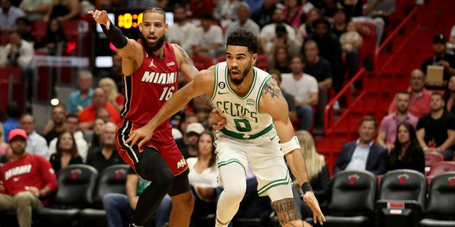 Jayson Tatum #0 of the Boston Celtics drives past Caleb Martin #16 of the Miami Heat during the second quarter at FTX Arena on October 21, 2022, in Miami, Florida. 