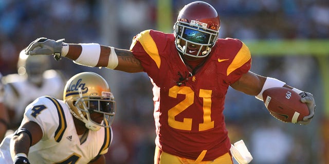 USC tailback LenDale White eludes the tackle of UCLA safety Jarred Page in the second quarter at the Coliseum Saturday.  