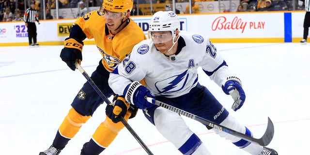 Nashville Predators defenseman Adam Wilsby (83) and Tampa Bay Lightning defenseman Ian Cole (28) battle for position during an NHL preseason game Sept. 30, 2022, at Bridgestone Arena in Nashville.