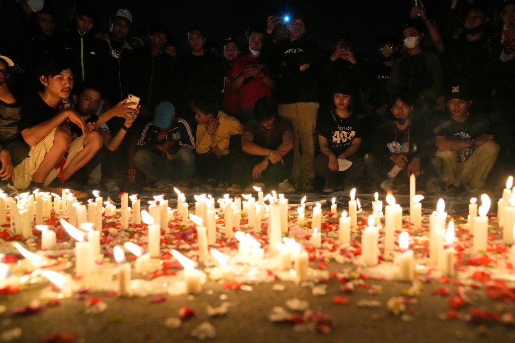 Indonesian soccer fans light candles during a vigil for the victims of the deadly stampede in Jakarta, Indonesia.