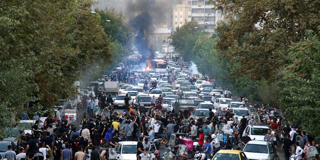 Demonstrators chant slogans during a protest in downtown Tehran, Iran, over the death of a woman who was detained by the morality police.