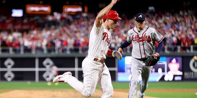 J.T. Realmuto, left, of the Philadelphia Phillies scores a run on an RBI single by Nick Castellanos against the Atlanta Braves during the seventh inning in Game 3 of the National League Division Series at Citizens Bank Park Oct. 14, 2022, in Philadelphia.