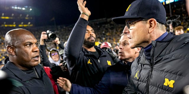 ANN ARBOR, MICHIGAN - OCTOBER 29: Head coach Jim Harbaugh of the Michigan Wolverines shakes hands with head coach Mel Tucker of the Michigan State Spartans at Michigan Stadium on October 29, 2022 in Ann Arbor, Michigan.