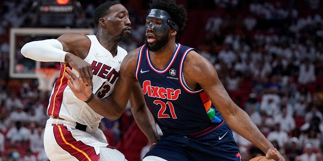 Philadelphia 76ers center Joel Embiid (21) drives up against Miami Heat center Bam Adebayo (13) during the first half of Game 5 of an NBA basketball second-round playoff series, Tuesday, May 10, 2022, in Miami. 