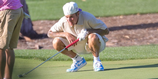 Justin Bieber eyes his shot on Saturday at the Hillcrest Country Club in Los Angeles.