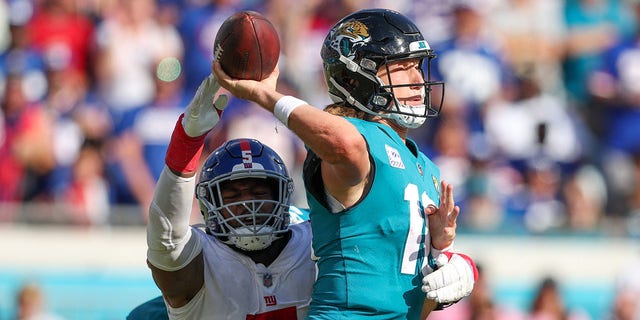 New York Giants defensive end Kayvon Thibodeaux, #5, pressures Jacksonville Jaguars quarterback Trevor Lawrence, #16, in the fourth quarter at TIAA Bank Field Oct. 23, 2022, in Jacksonville, Florida.