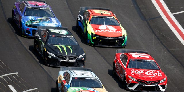 HAMPTON, GEORGIA - JULY 10: Denny Hamlin, driver of the #11 Coca-Cola Toyota, Kyle Busch, driver of the #18 M&amp;M's Crunchy Cookie Toyota, Kurt Busch, driver of the #45 Monster Energy Toyota, William Byron, driver of the #24 Axalta Chevrolet, and Alex Bowman, driver of the #48 Ally Milestone Chevrolet, race during the NASCAR Cup Series Quaker State 400 at Atlanta Motor Speedway on July 10, 2022, in Hampton, Georgia.