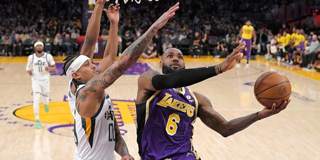 Los Angeles Lakers forward LeBron James, right, shoots as Utah Jazz guard Jordan Clarkson, center, and Danuel House Jr. defend during the first half of a game Feb. 16, 2022, in Los Angeles.