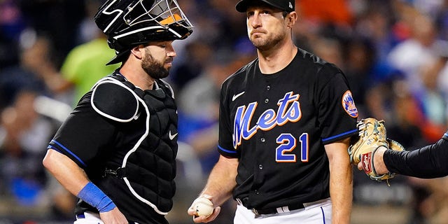 New York Mets starting pitcher Max Scherzer, #21, waits on the mound with catcher Tomas Nido during a pitching change during the fifth inning of Game 1 of a National League wild-card baseball playoff series against the San Diego Padres, Friday, Oct. 7, 2022, in New York. 