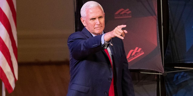 Former Vice President Mike Pence points as he arrives to speak at a campus lecture hosted by Young Americans for Freedom at the University of Virginia in Charlottesville, Va., on April 12, 2022.